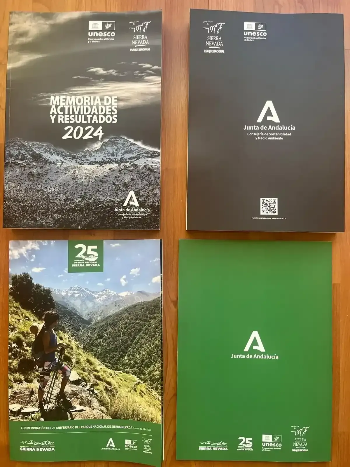 Cajas y cuadernos marrones sobre una superficie blanca, con texto y diseños geométricos coloridos.