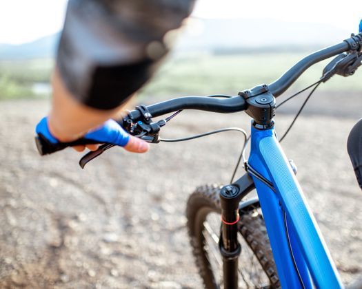 Una persona va en bicicleta de montaña azul por un camino de tierra.