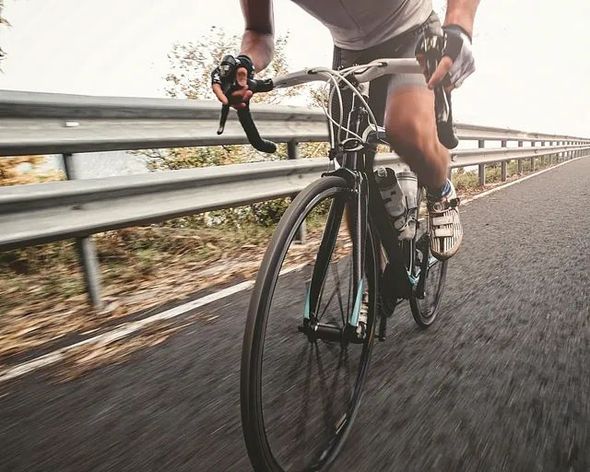Un hombre va en bicicleta por una autopista.