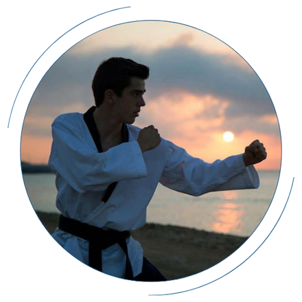 Un hombre está practicando artes marciales en la playa al atardecer.