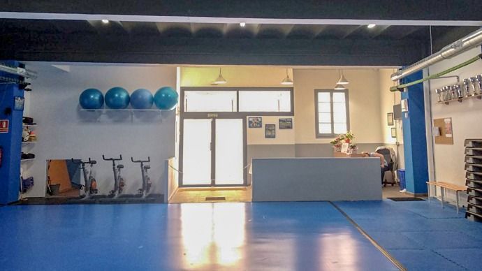 Un gimnasio con suelo azul y un mostrador de recepción.