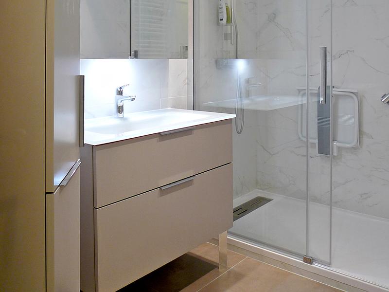 Salle de bains avec douche en second plan