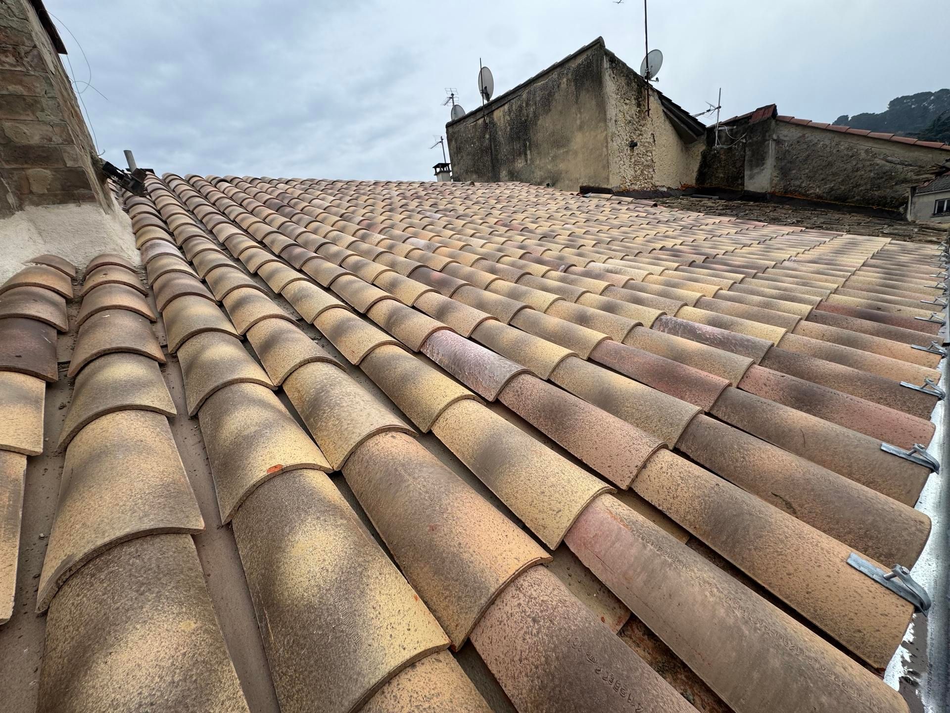 Toiture en tuiles avec une arête en forme de Y, vue de dessus, entourée de matériaux de construction.