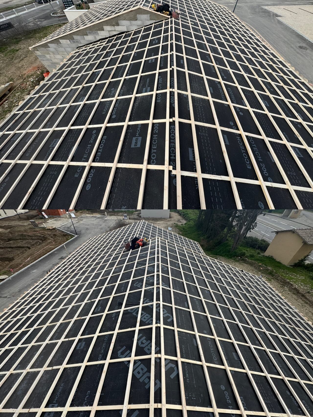 Toiture en construction avec poutres en bois apparentes et sous-toiture noire, à l'extérieur avec vue sur la ville.