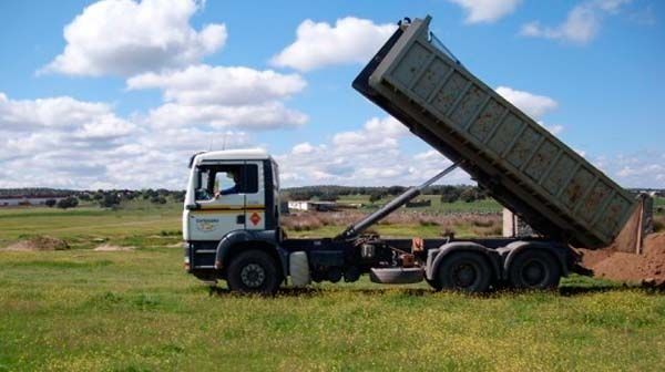 Un camión volquete está estacionado en un campo de hierba.