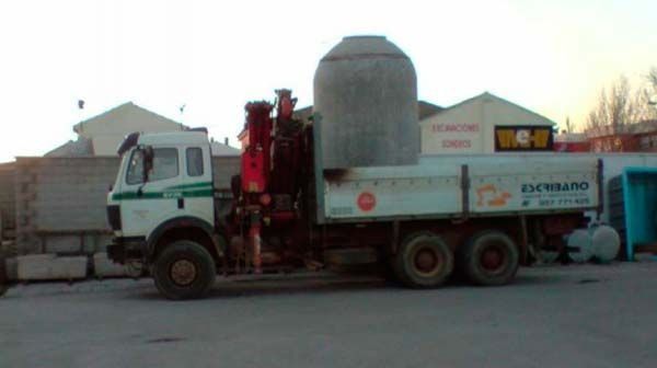 Un camión blanco con una grúa en la parte trasera está estacionado en un estacionamiento.