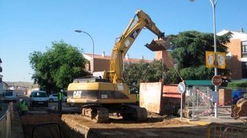 Una gran excavadora amarilla está cavando un hoyo en el suelo.