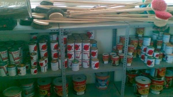 Un estante lleno de latas y cepillos.