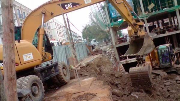 Una excavadora está cavando un hoyo en el suelo.