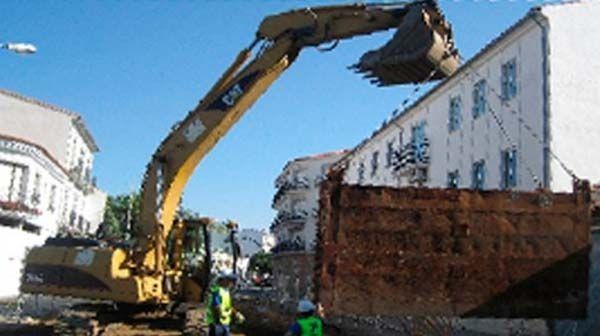 Una excavadora está levantando un gran trozo de madera.