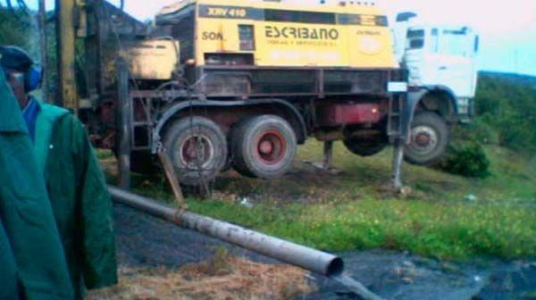 Un hombre con una chaqueta verde está parado frente a un camión amarillo que tiene escrito Outerspace en la parte trasera.