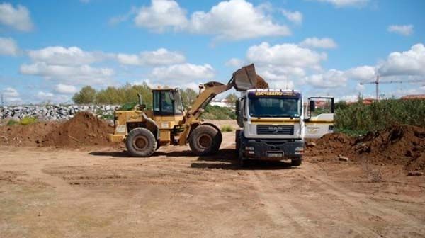 Una excavadora está cargando tierra en un camión.