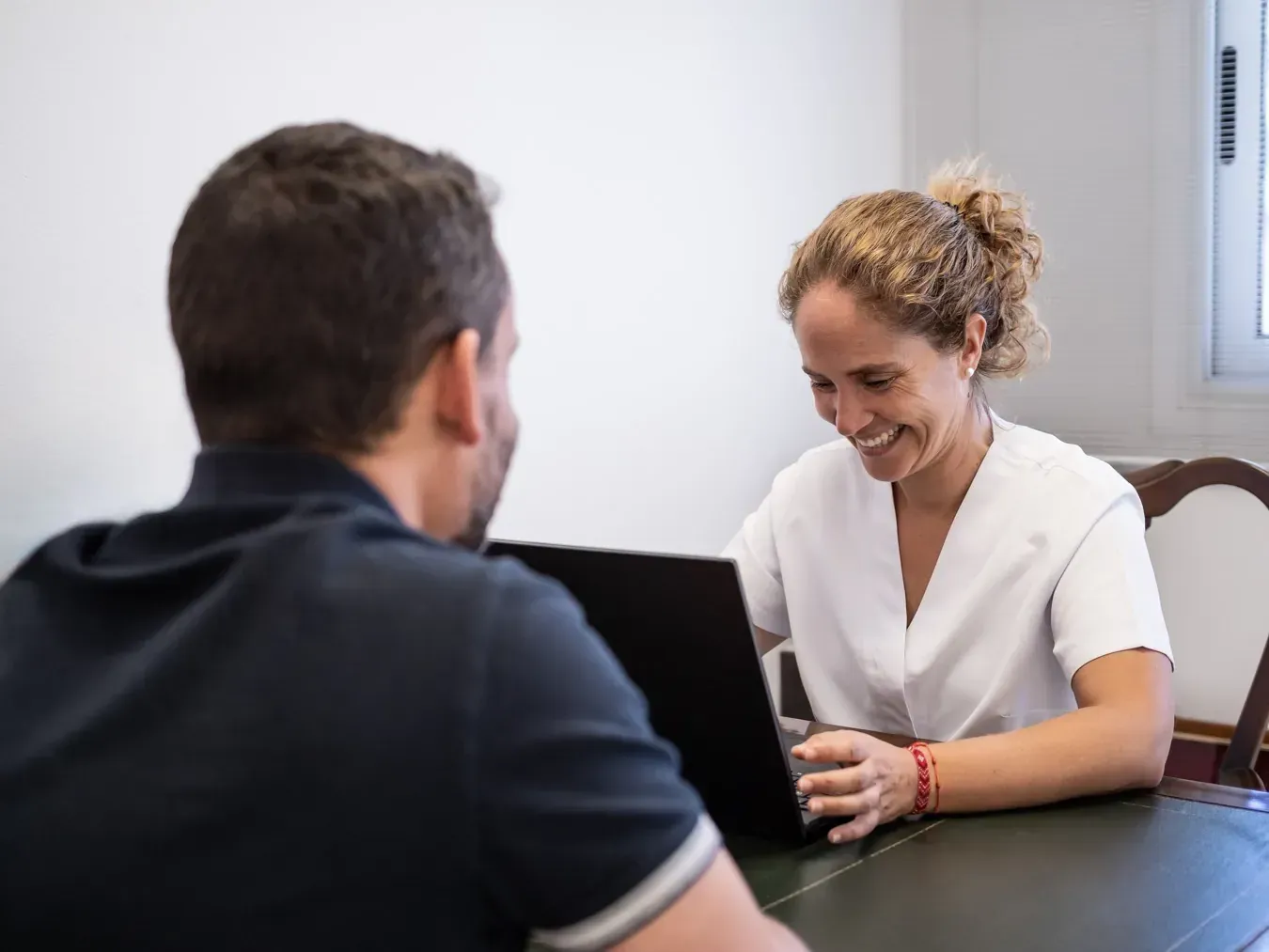 Una persona se sienta frente a un proveedor de atención médica sonriente
