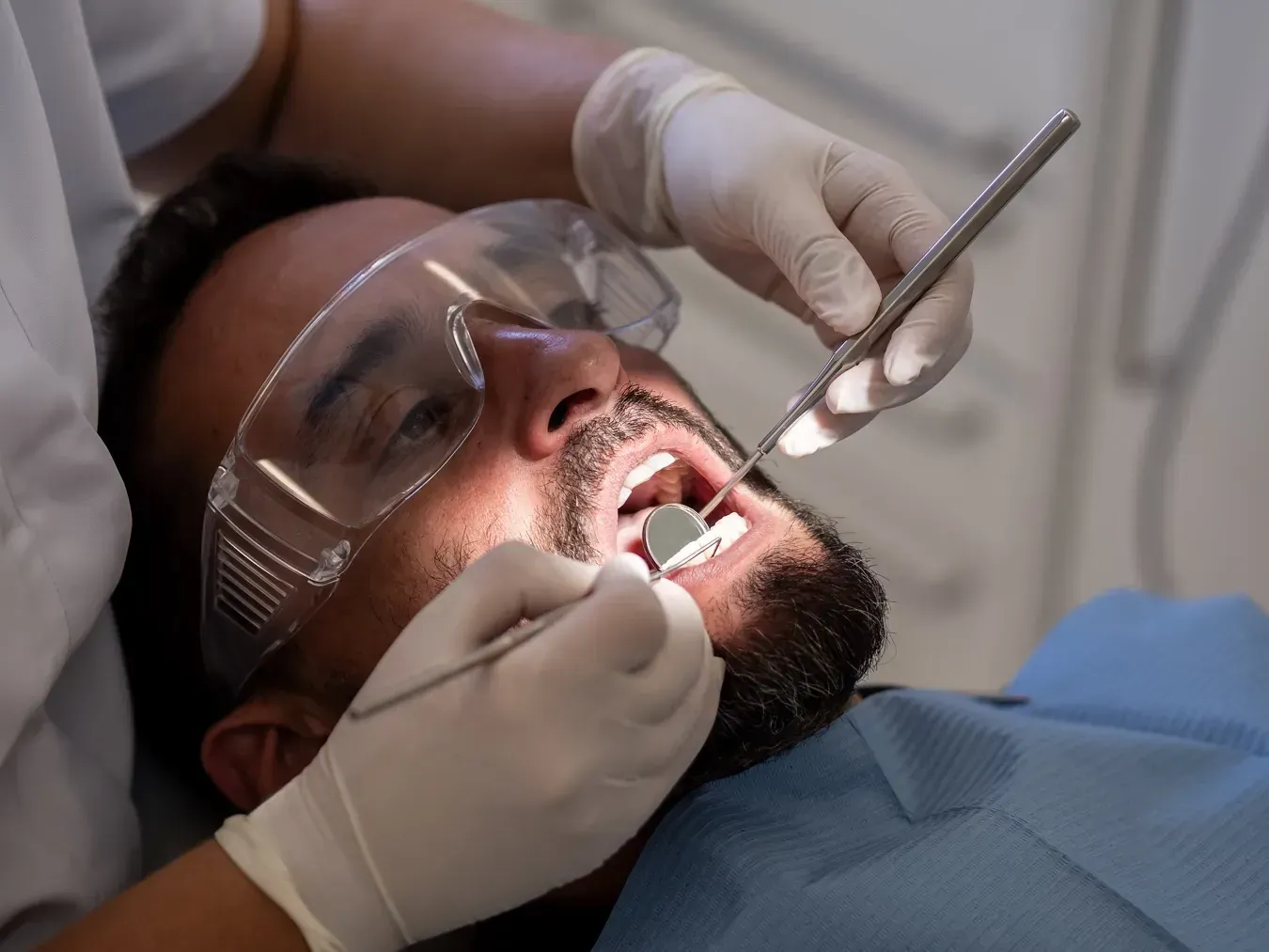 Dentista examina los dientes de un paciente con herramientas