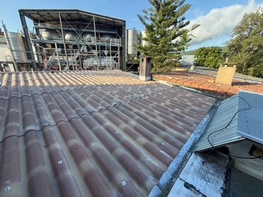Vue du toit montrant une toiture en tôle ondulée et la structure endommagée.