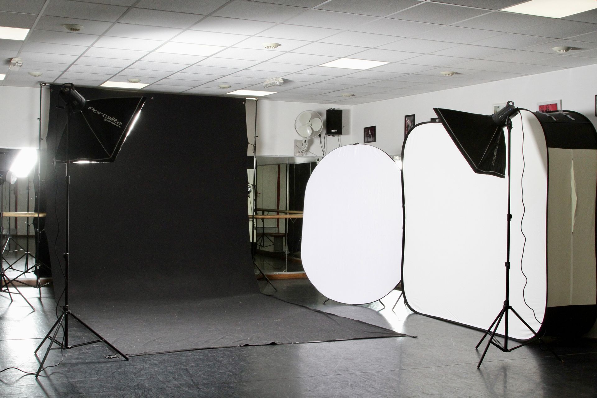 Studio photo avec fond noir, matériel d'éclairage et réflecteurs blancs