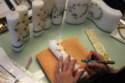 Eine Person zeichnet mit einem Bleistift auf eine Kerze