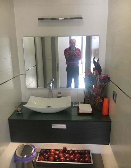 Un hombre se toma una foto en el espejo del baño.