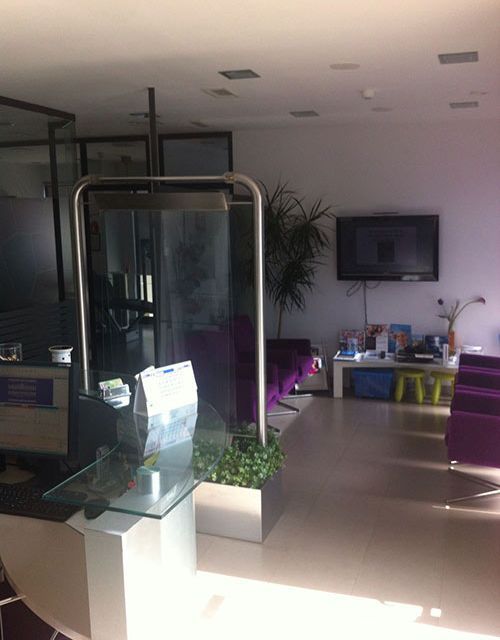 Una habitación con sillas moradas y un televisor en la pared.