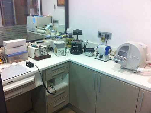 Un laboratorio dental con mucho equipamiento en el mostrador.