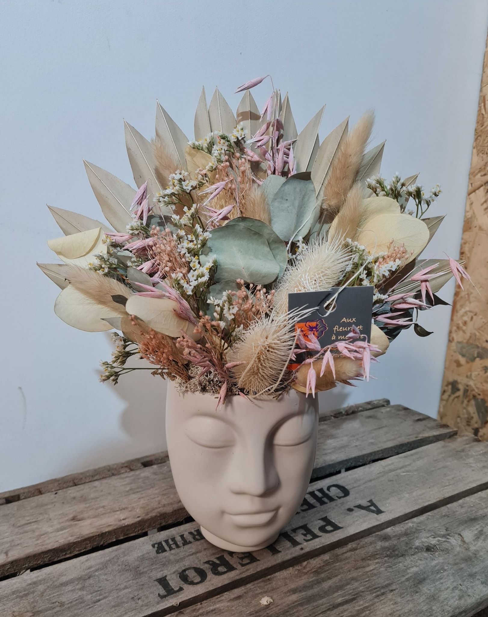 Compositions de fleurs séchées dans un cache pot visage