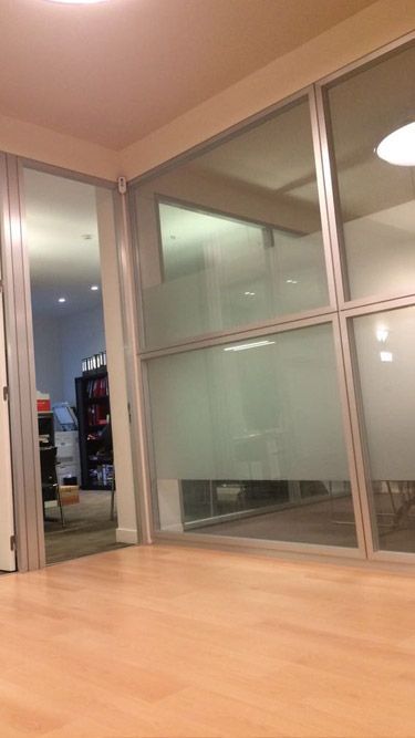 Una habitación con muchas ventanas y suelo de madera.