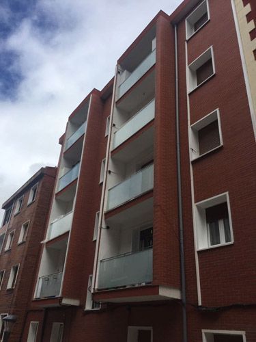 Un edificio de ladrillo con muchas ventanas y balcones.