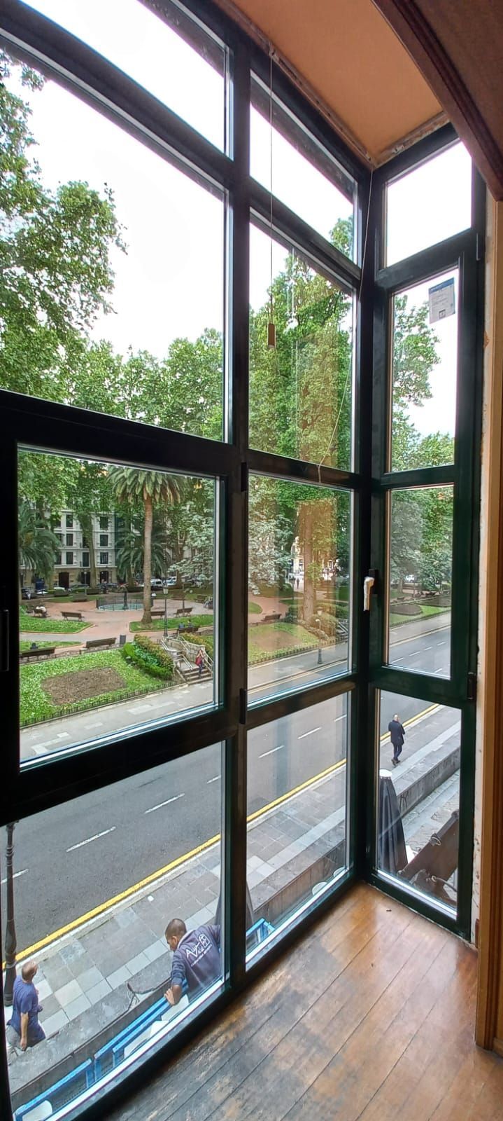 Un balcón con barandilla de madera y cristal blanco.