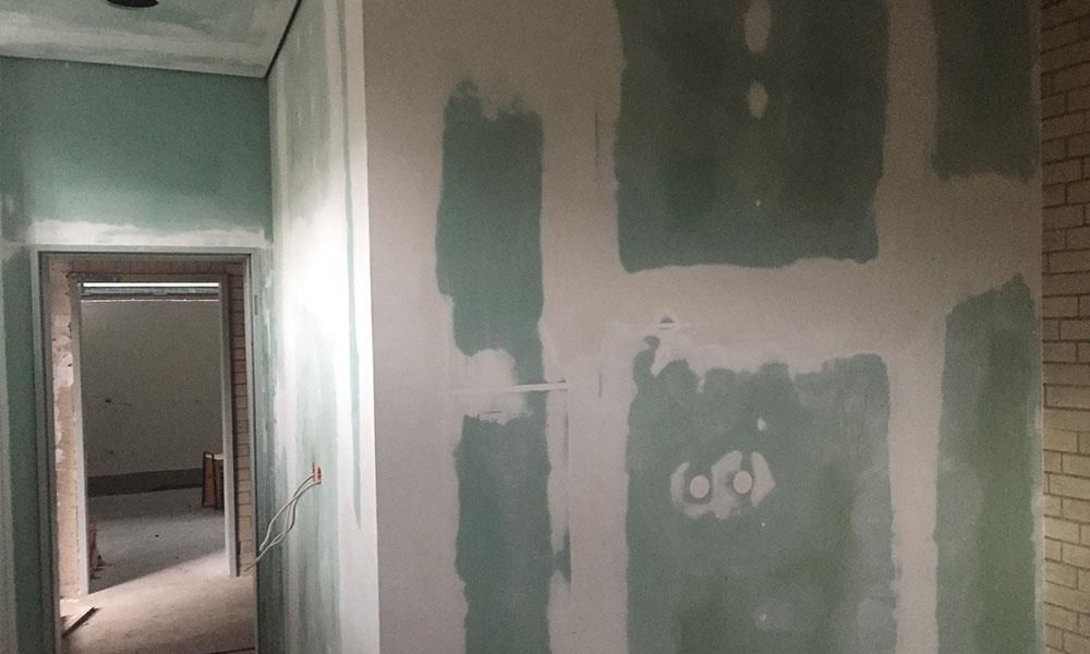 Ein Flur mit einer Tür und einer Wand, die gerade renoviert wird.