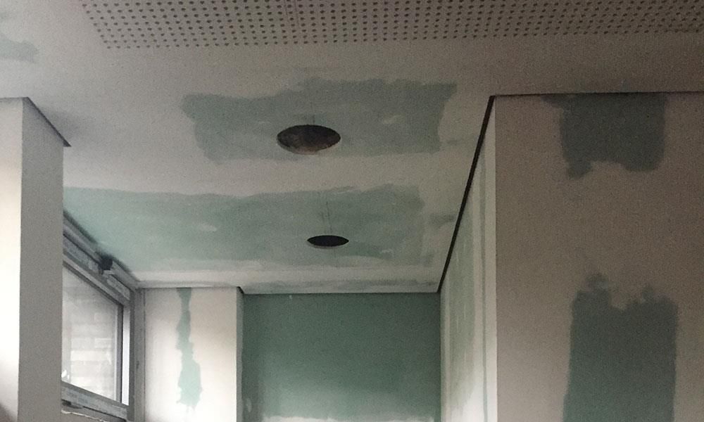 Ein Raum mit einem Loch in der Decke und einem Fenster.