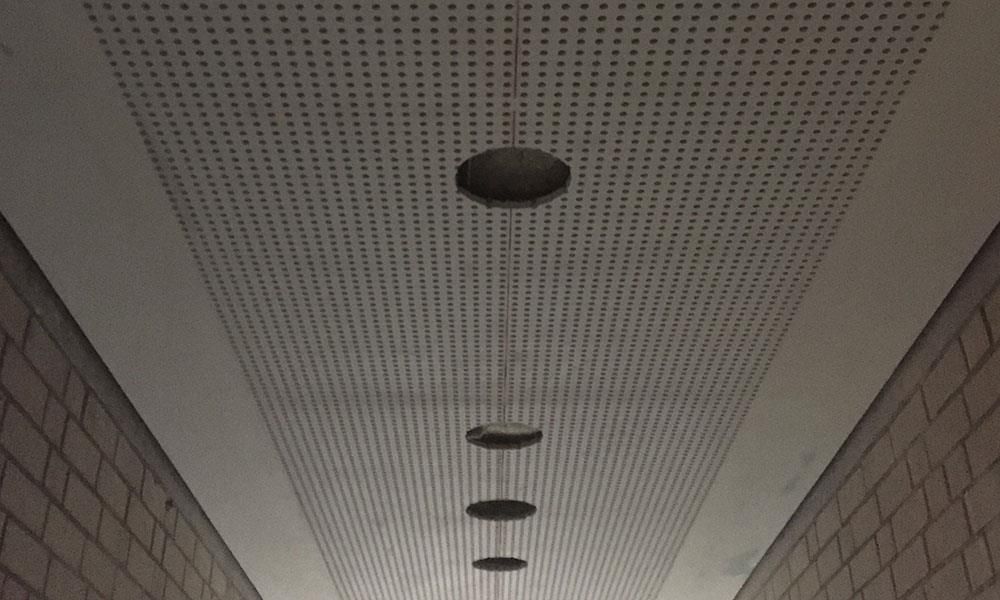 Ein langer Flur mit einer Decke, die Löcher hat