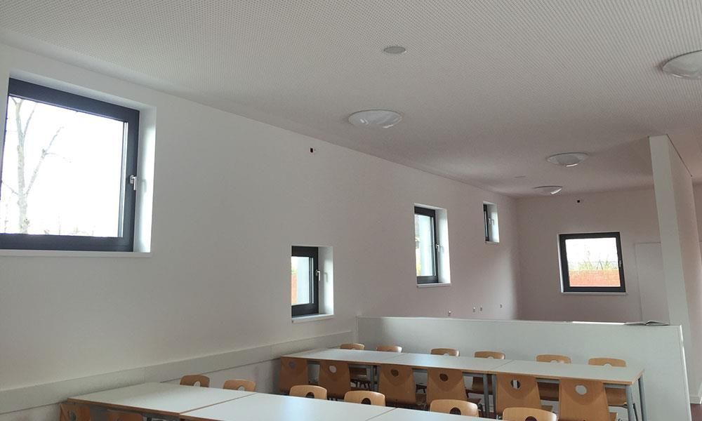 Ein Esszimmer mit Tischen und Stühlen und einem Fenster