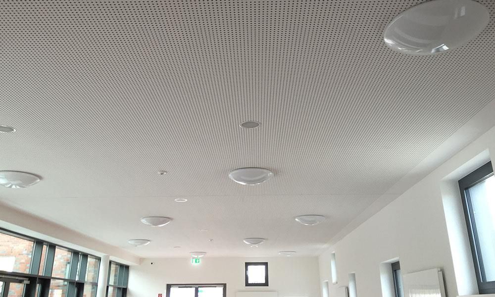 Ein Raum mit weißer Decke und vielen Fenstern.