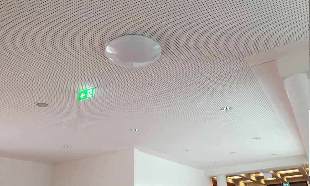 Eine weiße Decke mit einem grünen Ausgangsschild darauf.