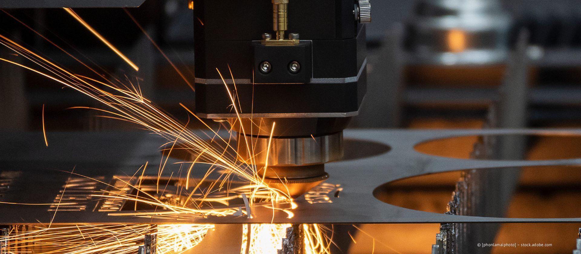 Funken sprühen, als eine CNC-Maschine in einer Fabrikhalle Metall schneidet