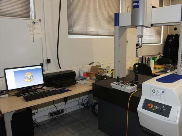 Ein Computer steht auf einem Schreibtisch neben einer Maschine mit der Aufschrift Zeiss