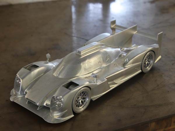 Ein silbernes Modell-Rennauto steht auf einem Tisch