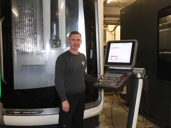 Ein Mann steht vor einer Maschine in einer Fabrik.