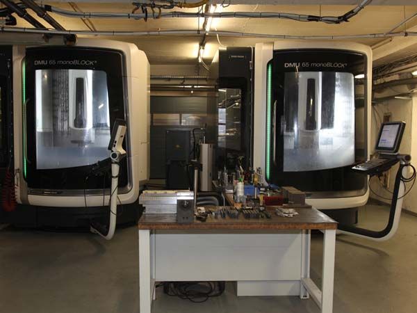 Zwei Maschinen stehen nebeneinander auf einem Tisch in einer Garage.