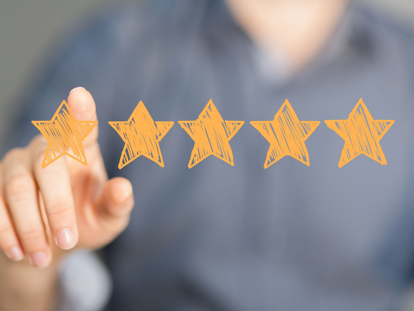 Le doigt d'une personne touchant une étoile dessinée parmi une rangée de cinq étoiles.
