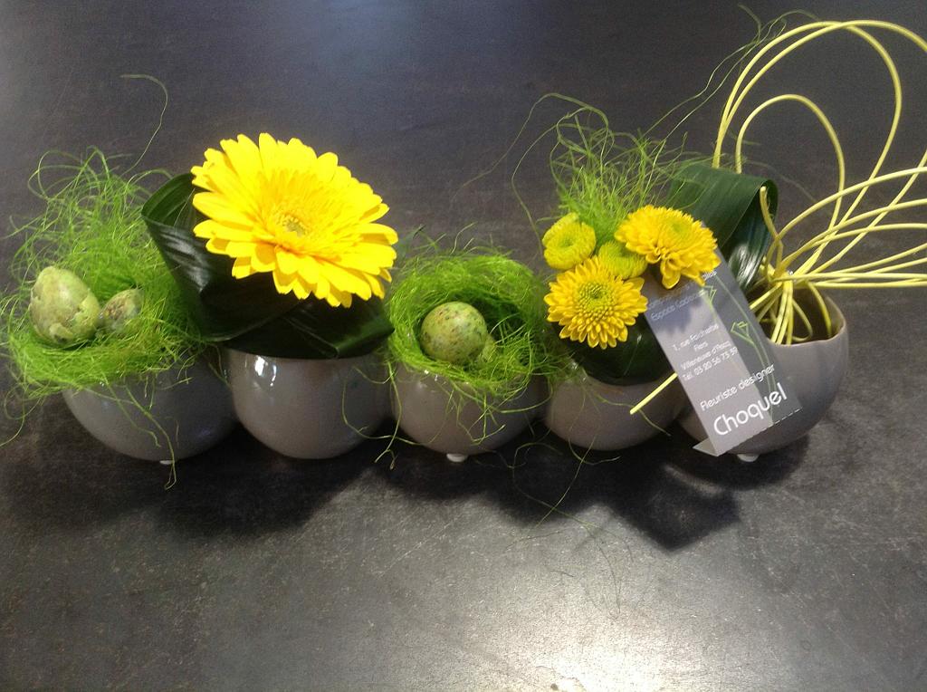 Cinq pot juxtaposé avec des fleurs jaunes