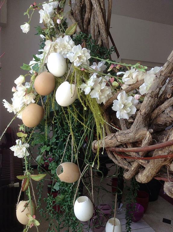 Des œufs dans une composition florale