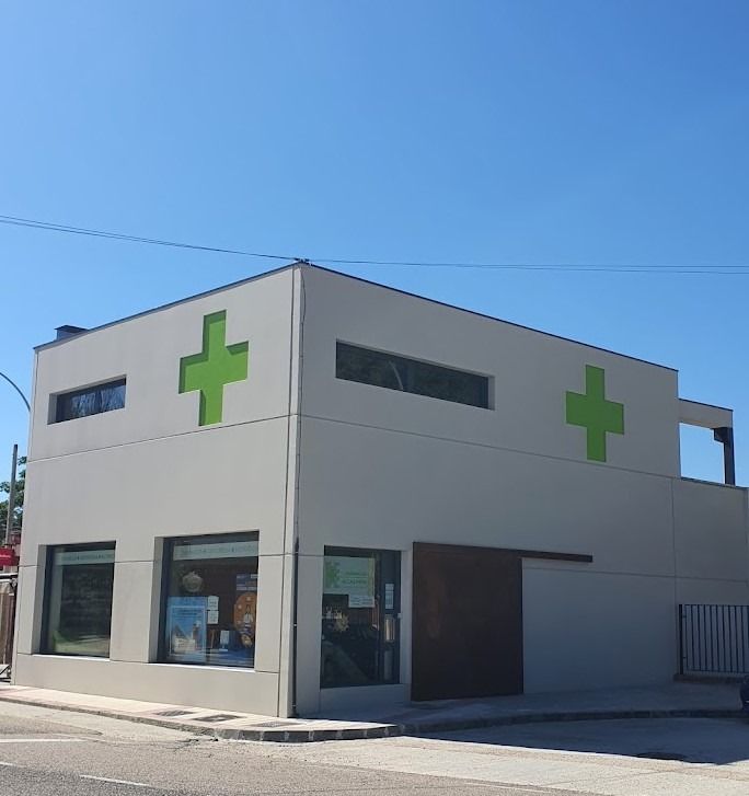 Un edificio blanco con una cruz verde en el costado