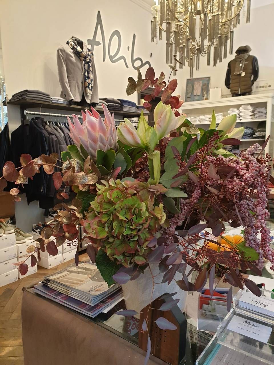 Ein Blumenstrauss auf einem Tresen in einem Bekleidungsgeschäft mit dem Schild „Alibi“.