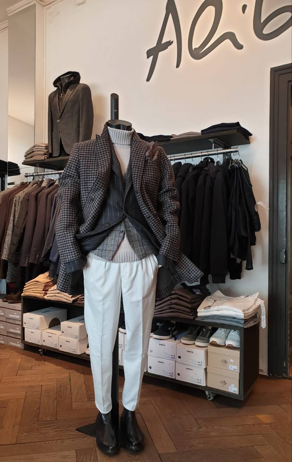 Schaufensterpuppe in einem Bekleidungsgeschäft. Sie trägt eine gemusterte Jacke, eine Weste, eine Hose und schwarze Stiefel.