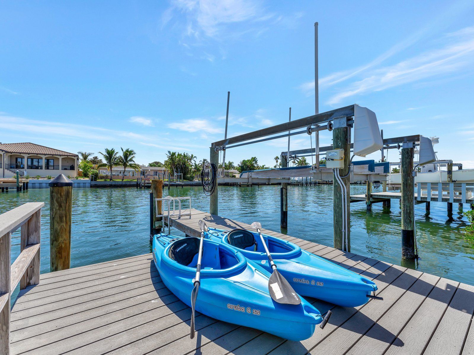 Two blue kayaks are docked on a dock next to a body of water.
