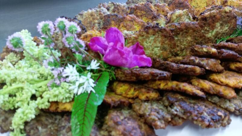 Ein Teller mit Essen und Blumen darauf auf einem Tisch.