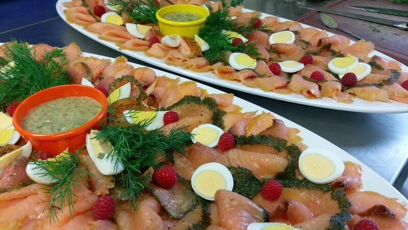 Zwei Teller mit Eiern, Himbeeren und Dip-Sauce auf einem Tisch.