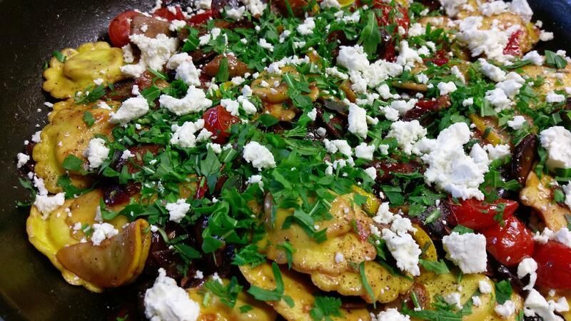 Eine Nahaufnahme einer Pfanne gefüllt mit Gemüse und Käse.