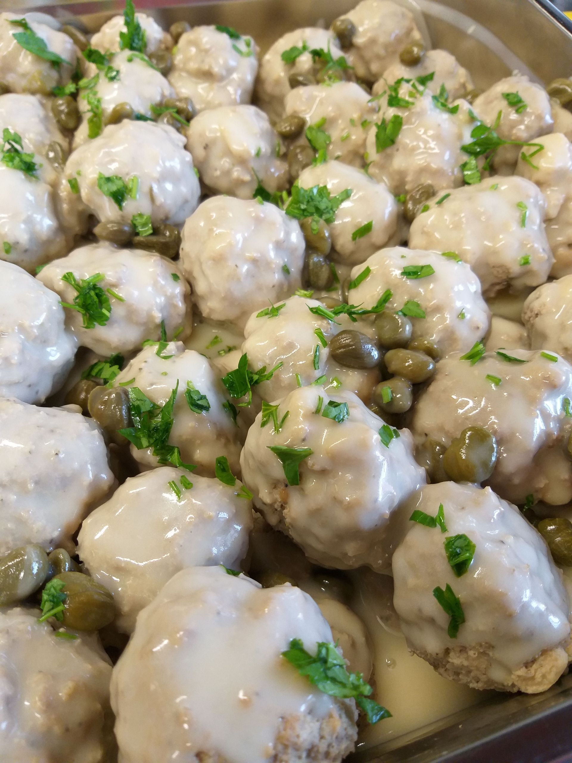 Eine Nahaufnahme einer Auflaufform gefüllt mit Fleischbällchen und Soße.